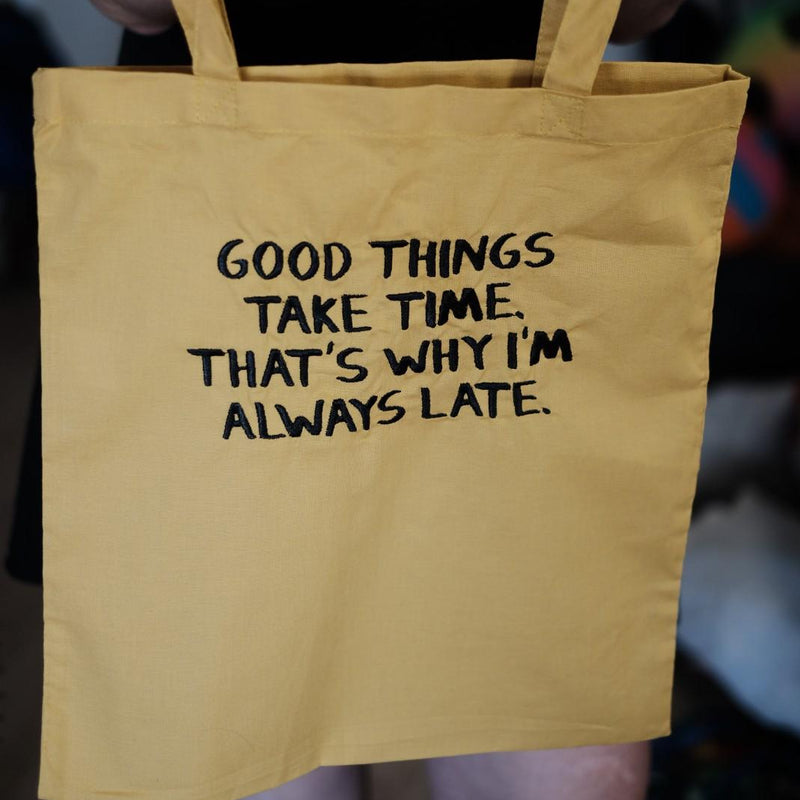 Bolsa de tela de lona color amarillo mostaza con cita divertida "Good Things Take Time"